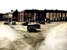 an old photo of cars parked in front of buildings