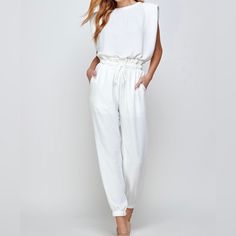 This White Jumpsuit Is Perfect For An All White Affair, Date Night Or Sunday Brunch. The Perfect On Trend Jumpsuit To Dress It Up, Or Dress It Down. Sleeveless Crew Neckline Relaxed Silhouette, Crinkle Woven Fabric With Padded Shoulders Elasticated Waist With Drawstring Half Lining For Comfort Jogger Pants With And Elasticated Cuff 100% Polyester Lining: 100% Rayon *Model 1 & 2 Wearing Medium/ 5'5 *Model 3 & 4 Wearing A Small/ 5'6 Size Numerical Bust Waist Hips Small 2 - 4 32" - 34" 27" 36" - 37 White Overall Jumpsuits And Rompers For Loungewear, All White Affair, White Jumpsuit, Sunday Brunch, All White, Jogger Pants, Crew Neckline, The Struts, Woven Fabric