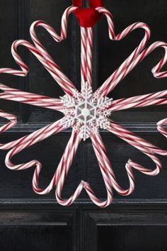 candy canes are arranged in the shape of a snowflake on a door