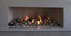 a fire place with rocks in it and flames coming out from the top one side