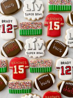 decorated football cookies are displayed on a table