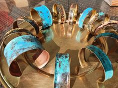 several rings that are sitting on top of a metal tray with blue and gold paint