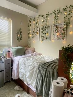 a bedroom with plants on the wall and lights hanging from the ceiling over the bed