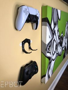 three video game controllers mounted to the wall next to each other on a yellow wall