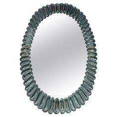 a round blue beaded mirror hanging on a wall next to it's reflection