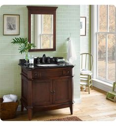 a bathroom with a sink, mirror and green tiled walls in the background is a chair