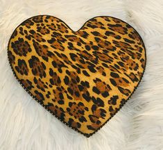 a heart shaped animal print pillow on white fur