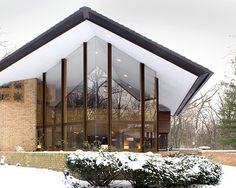 a large glass building with snow on the ground