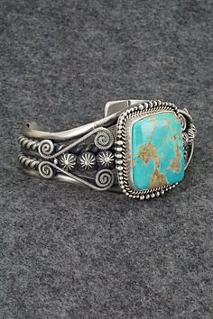 This beautiful and substantial Royston turquoise and sterling silver bracelet was made by Navajo silversmith Michael Calladitto. The back is signed M&R Calladitto, Navajo and stamped .925.Size: 5 1/2" (will fit up to a 6 7/8" wrist)Gap: 1 3/8"Width: 1 1/2"Free shipping on all orders! We ship with USPS and always include tracking. All orders ship within a day of payment.Returns are accepted up to 30 days after you receive your order. Just send us a message. Our shop offers cash back or store cred Artisan Turquoise Sterling Silver Bracelet, Engraved Turquoise Sterling Silver Bracelet Gift, Elegant Engraved Turquoise Sterling Silver Bracelet, Elegant Turquoise Engraved Sterling Silver Bracelet, Artisan Turquoise Engraved Bracelets, Artisan Turquoise Engraved Bracelet, Elegant Turquoise Concho Jewelry, Southwestern Untreated Bracelet Jewelry, Bohemian Engraved Turquoise Sterling Silver Bracelet