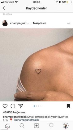 a woman with a small heart tattoo on her chest