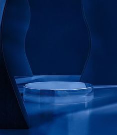 a blue vase sitting on top of a table next to a white plate in front of it