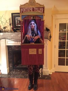 a woman standing in front of a fake fortune teller machine with her hands on her hips