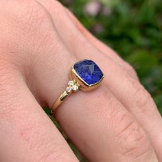 This deep purple tanzanite ring is a beautiful statement for everyday. Cut in our much loved Sugarloaf it is set in 14k and accented by a diamond clusters. Finished on a handmade seagrass band, you won't want to take this little beauty off. Approximate stone size: 9mmx 9mm Approximate stone weight: 4cts Mohs Hardness scale: 7-7.5 This one of a kind piece is handmade with love in Emily's Hudson Valley studio. If you have questions about sizing, shipping or need help deciding on your perfect piece Purple Tanzanite, Colored Stone Engagement Rings, Purple Stone Ring, Stacked Engagement Ring, Hardness Scale, Purple Stone Rings, Birthstone Stacking Rings, Ring My Bell, Purple Diamond