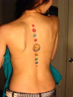 the back of a woman's body with planets on it