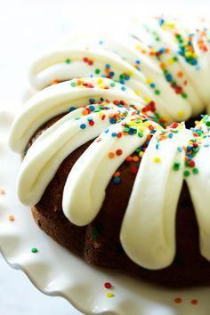 a bundt cake with white frosting and sprinkles on a plate