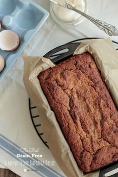 a loaf of bread sitting on top of a pan next to an egg and spoon