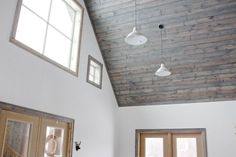 a living room filled with furniture next to two windows and a ceiling mounted light fixture