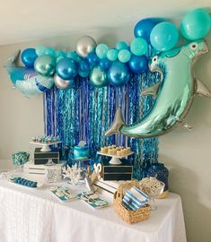 a table topped with blue and silver balloons