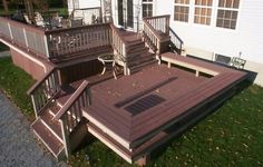 a deck with steps and railings in front of a house