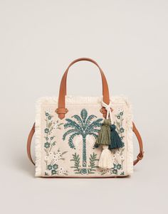 Beautiful embroidery on cotton and jute fabric, fringe and faux leather accents dress our Alljoy Landing Palm Tree Boho Fringe Satchel Crossbody in style while the zipper closure, adjustable & removable crossbody strap and top handles show her smarts. The interior zip plus two slip pockets easily hold the largest i