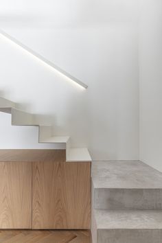 the stairs are made of concrete and have light wood treads on each one side