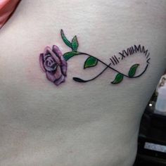 a woman's stomach with a rose tattoo on it