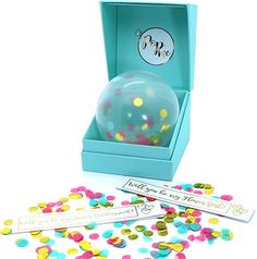 a blue box filled with confetti and a ball