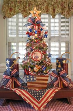 a christmas tree decorated with red, white and blue ribbons in the shape of an american flag