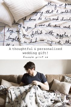 a man sitting on top of a couch under a blanket next to a bed covered in pillows