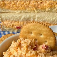 a bowl filled with chicken salad next to crackers