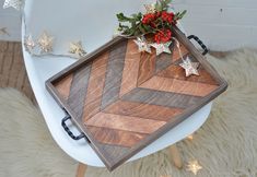 a wooden tray sitting on top of a white chair next to a christmas tree and star decorations