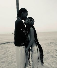 a man and woman kissing on the beach