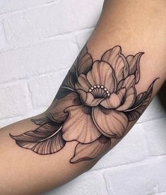 a woman's arm with a flower tattoo on it