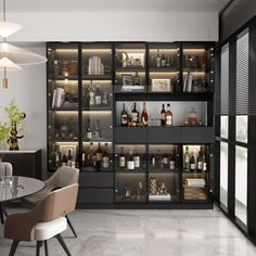 a room filled with lots of bottles and glasses on top of shelves next to a dining table