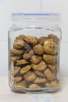 a glass jar filled with cookies on top of a counter