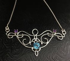 I love Victorian and Renaissance style statement necklaces with a magical and timeless flair, and I hope I've captured it within this piece! I shall fabricate for you this gorgeous Elvish/Renaissance style necklace, in sterling silver, with a center 8mm Blue Topaz and two side 4mm Amethyst gemstones. The center gemstone is 8mm round and the two sides are 4mm round. The chain will be soldered to each side and I will use a 1.2mm thick sterling box chain with a lobster claw clasp for added straight Bohemian Necklace With Sterling Silver Clasp, Bohemian Necklace With Sterling Silver Clasp For Gift, Artisan Sterling Silver Necklace For Gift, Spiritual Necklace With Sterling Silver Clasp As Gift, Artisan Birthstone Necklace For Gifts, Artisan Necklace With Sterling Silver Clasp, Artisan Necklace With Sterling Silver Clasp For Gift, Artisan Sterling Silver Necklace With Birthstone, Artisan Silver Necklace With Birthstone