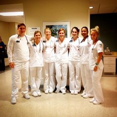 a group of people in white uniforms posing for a photo