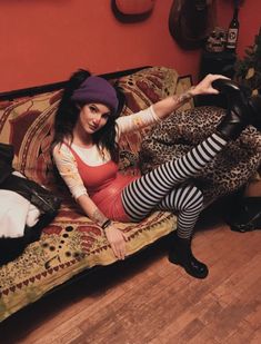 a woman sitting on top of a couch wearing tights