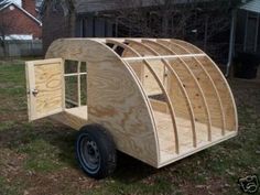 a small wooden trailer sitting in the grass