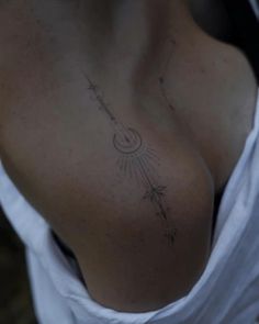 a woman's chest with an arrow tattoo on her left side, and stars in the sky