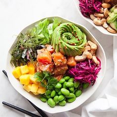 two white bowls filled with different types of food and chopsticks next to each other