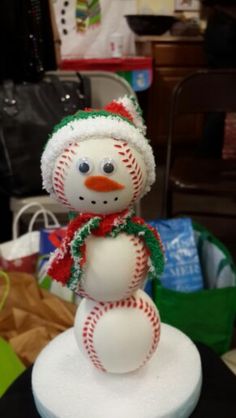 a snowman with a hat and scarf on it's head sitting on top of a table