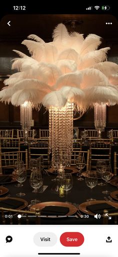 an image of a chandelier with white feathers on the centerpiece and place settings