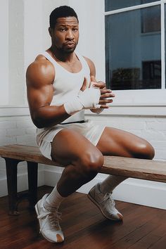 a man sitting on top of a wooden bench