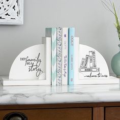 two books are sitting on top of a marble table next to a vase with flowers