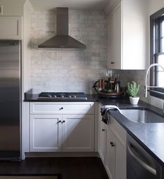 a kitchen with white cabinets and black counter tops