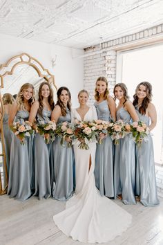 the bride and her bridesmaids pose for a photo in front of a mirror