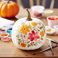 a painted pumpkin sitting on top of a wooden table