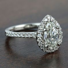 an oval cut diamond ring on a wooden table