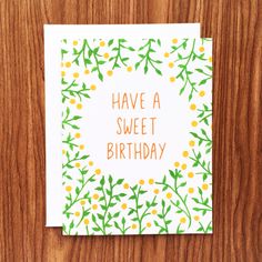 a greeting card with the words have a sweet birthday written in orange and green flowers